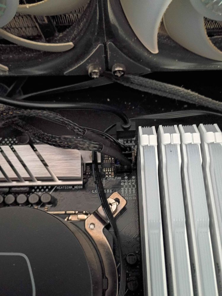 Close-up of memory sticks and a CPU cooler reattached inside a desktop.